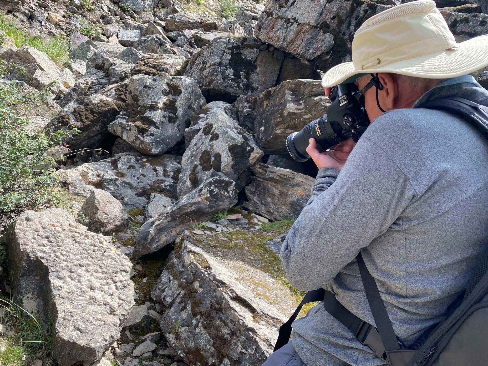 A tour participant capturing trilobite trace fossils at Lake Louise