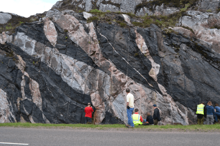 Examining a multi-coloured outcrop of gneiss