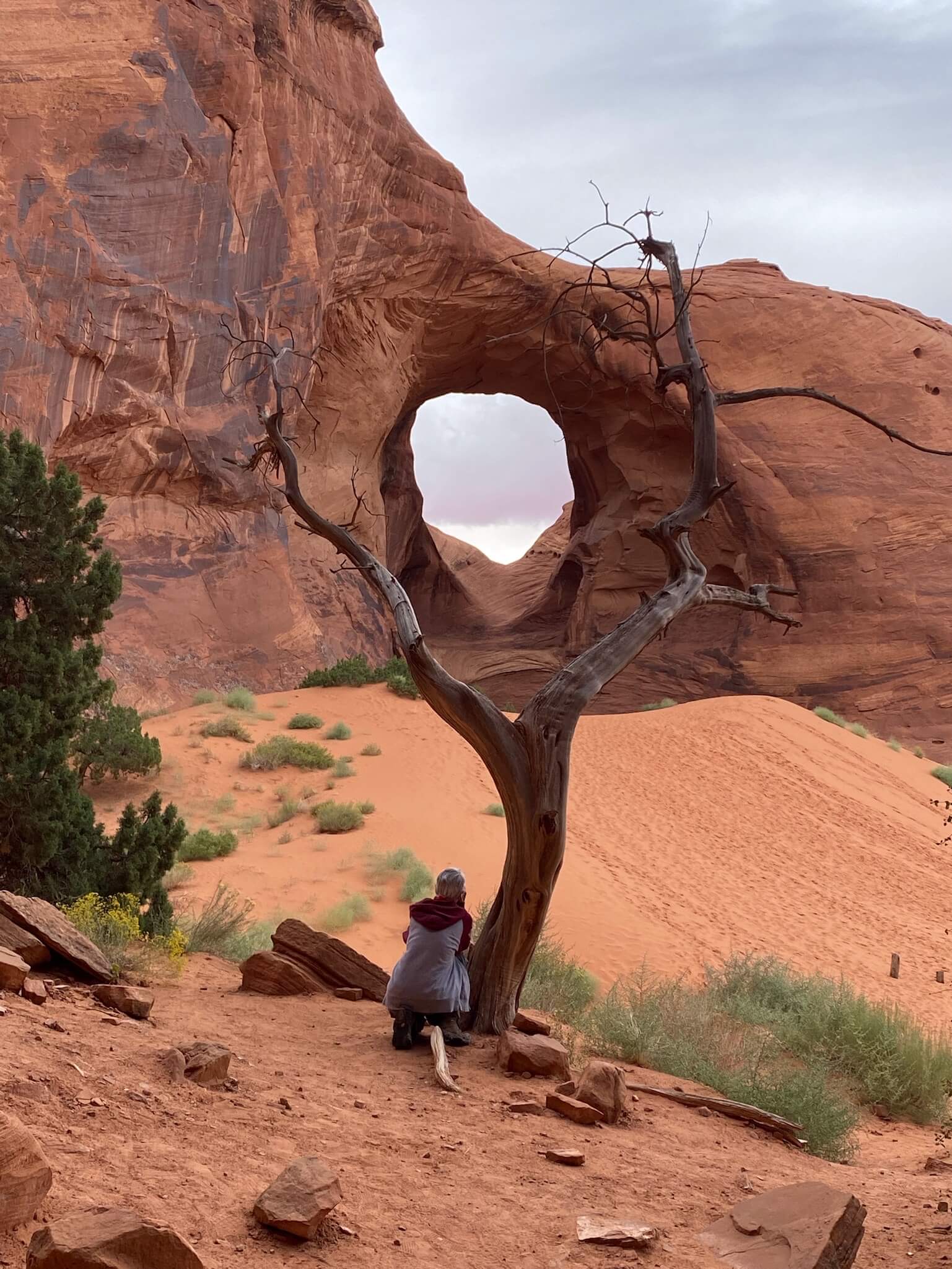 A tour participant looking through a window in Monument Valley